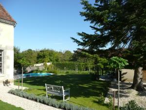 a yard with a bench and a swimming pool at La Forge in Sainpuits
