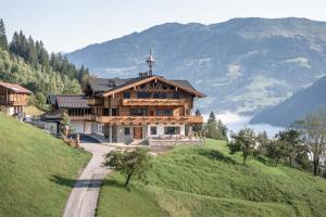 a house on a hill with a cross on the top at Das Grabnergut in Bad Hofgastein
