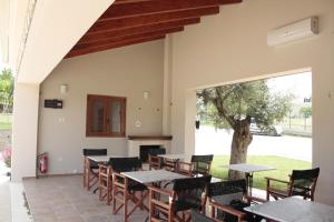 a patio with tables and chairs and a tree at Evinos Garden in Tríkorfon