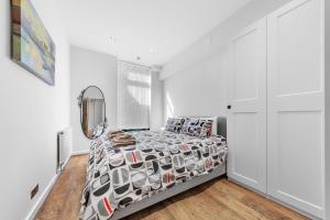 a bedroom with a bed and a mirror at Shortlet Express, Stunning 3 bedroom Barking Apartment, by Train Station in Barking