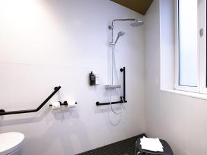 a white bathroom with a shower and a toilet at ibis Styles Paris Gare De Lyon TGV in Paris +65 photos