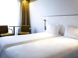 a bedroom with a large white bed and two chairs at ibis Styles Paris Gare De Lyon TGV in Paris +65 photos
