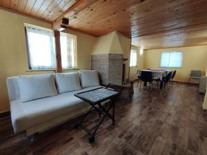 a living room with a couch and a table at Къща за гости При Комина - Guest House By the Chimney in Dryanovo