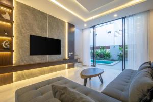 a living room with a couch and a tv at Luxury Pool Villa Samui - Elabel in Amphoe Koh Samui