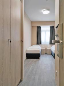 a small room with two beds and a window at Malom Munkásszálló in Karcag