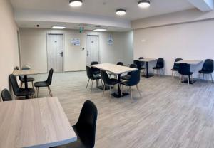 a large room with tables and chairs and tablesktop at Malom Munkásszálló in Karcag
