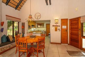 Kruger Park Lodge Unit No 304 في هازيفيو: مطبخ وغرفة طعام مع طاولة وكراسي خشبية