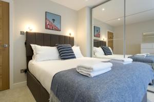 a bedroom with two beds and a large mirror at Madison Hill - Byrne Garden 2 - One bedroom home in London +8 photos