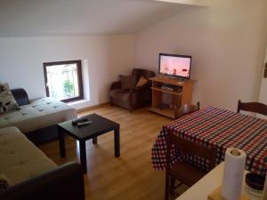 a living room with a couch and a tv at Sun Apartments in Tivat