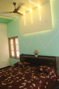 a bedroom with a bed and a ceiling fan at Aashiyana Idukki in Kūmudi