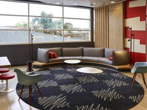 una sala de estar con un sofá y una alfombra en Ibis Guaxupe, en Guaxupé