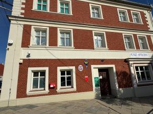 a red brick building with a door on a street at Apartamenty w Dobromierzu 