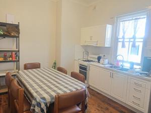 Una cocina con una mesa y sillas y un fregadero. en Tiny Single Room in Earlwood House - EW7, en Sídney 1 foto más