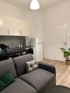 a living room with a couch and a kitchen at A little love nest in Brussels +5 photos