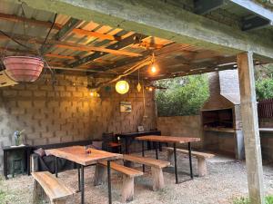 een terras met twee houten tafels en een bakstenen muur bij Posada El Duende in La Pedrera +7 foto's