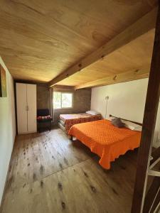 Un dormitorio con dos camas y techo de madera. en Posada El Duende, en La Pedrera