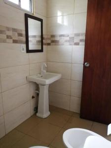 Un baño con un lavabo blanco y un espejo. en Posada El Duende, en La Pedrera 7 fotos más