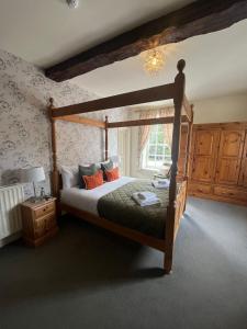 a bedroom with a wooden bed and a window at The George Inn in Lower Brailes