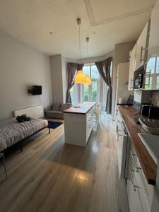 a large kitchen and living room with a table and a couch at Apartment close to City Centre in Winchester