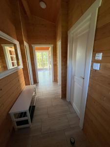 Un pasillo en una casa de madera con un banco. en Silence-Lodge, en Müncheberg 1 foto más