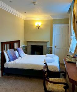 a bedroom with two beds and a desk and a fireplace at The Lairgate in Beverley