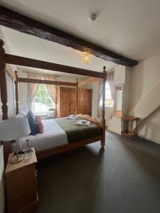 um quarto com uma cama grande com estrutura de madeira em The George Inn em Lower Brailes