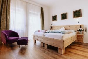 a bedroom with a wooden bed and a purple chair at Arthotel Arabella in Bad Nauheim