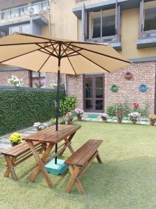 una mesa de picnic con una sombrilla en un patio en Rishani-alay An Exclusive Affair by the Fountain, en Raichak