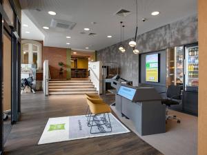 Una oficina con un escritorio y sillas y un perro al fondo. en ibis Styles Coburg, en Coburg