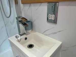 a bathroom sink with a faucet on top of it at Luxury Detached Hideaway near town, beach and woods in Clevedon