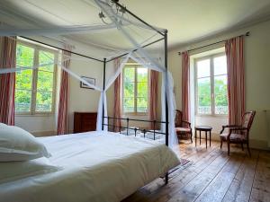 a bedroom with a canopy bed and two chairs at Queen's Escape in Martel