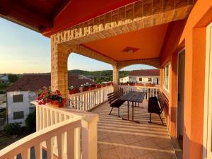 Un patio con una mesa y sillas en un balcón. en House with outdoor pool in Tisno, en Tisno
