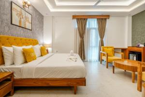 a bedroom with a large bed and a yellow chair at Lime Tree 3BHK Service Apartment Near India Expo Mart Greater Noida in Greater Noida