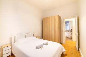 a bedroom with a white bed and a wooden cabinet at GuestReady - Chic retreat in Clichy in Clichy
