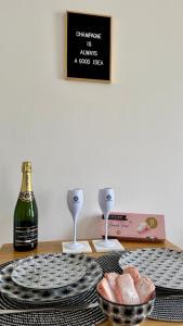 a table with a bottle of wine and a plate of food at La Bulle Millésimée - à deux pas de la Gare et de l'Avenue de Champagne in Épernay