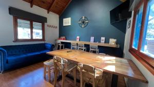 a living room with a table and a blue couch at Casa Yuco Hostel in San Martín de los Andes