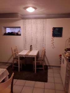 kuchnia ze stołem i krzesłami w pokoju w obiekcie Pension Müller w mieście Barweiler