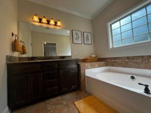 a bathroom with a large tub and a large mirror at Hahira 3-Bedroom Home near Wild Adventures, Sleeps 12 in Hahira +33 photos