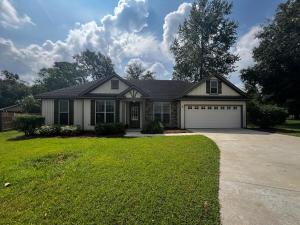 a house with a large yard with a garage at Hahira 3-Bedroom Home near Wild Adventures, Sleeps 12 in Hahira