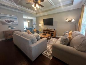 a living room with two couches and a flat screen tv at Hahira 3-Bedroom Home near Wild Adventures, Sleeps 12 in Hahira