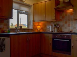 a kitchen with wooden cabinets and a sink and a window at The Bungalow in Pentrich