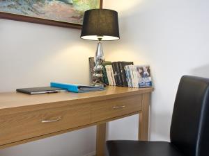 a desk with a lamp and books on it at Devon Villa Garden Apartment in Torquay