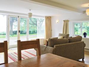una sala de estar con un sofá y una mesa en Winhill Cottage, en Bamford