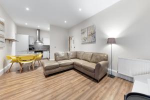 a living room with a couch and a table at Shortlet Express, Stunning 3 bedroom Barking Apartment, by Train Station in Barking