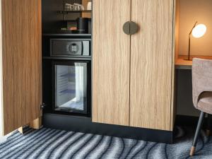 a kitchen with a microwave and a cupboard at Mercure Amsterdam North Station in Amsterdam