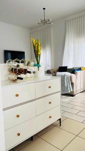 a white dresser with a vase of yellow flowers on top of it at Luxury Two-Story Loft - Beautiful Golf Course Views in Roodepoort