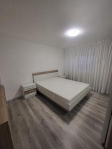 a bedroom with a white bed and wooden floors at 5,5 pc apartment, garden but Pool only upon request in Avry