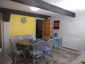 a dining room with a table and chairs and a clock at Happy Days in Whitby +6 photos