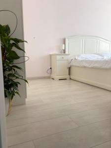 Un dormitorio con una cama y suelo de madera. en RED3 ARAD Apt-Fast Wi-Fi-Self Check-in, en Arad