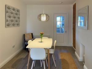 a dining room with a white table and chairs at Harbour Walk in Amble